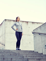 Image showing smiling sportive woman on stairs at city