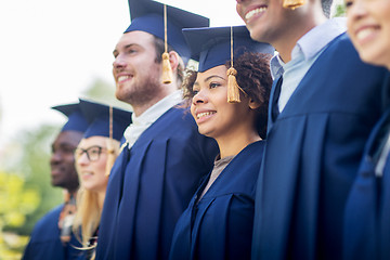 Image showing happy students or bachelors in mortar boards