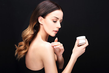 Image showing Beautiful young woman rubbed cream 
