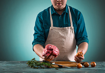 Image showing Butcher cutting pork meat on kitchen