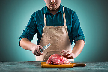 Image showing Butcher cutting pork meat on kitchen