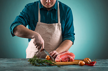 Image showing Butcher cutting pork meat on kitchen