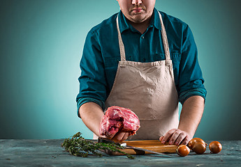 Image showing Butcher cutting pork meat on kitchen