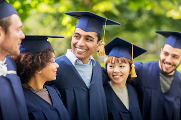 Image showing happy students or bachelors in mortar boards