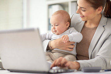 Image showing happy businesswoman with baby and laptop at office