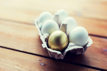 Image showing close up of white and gold eggs in egg box