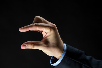 Image showing close up of businessman hand showing small size