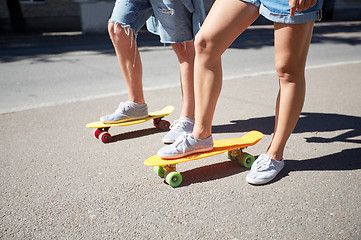 Image showing teenage couple riding skateboards on city street