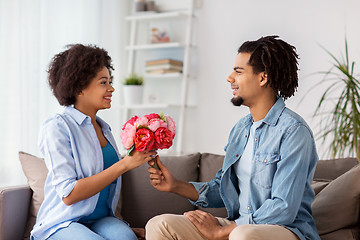 Image showing happy couple with bunch of flowers at home