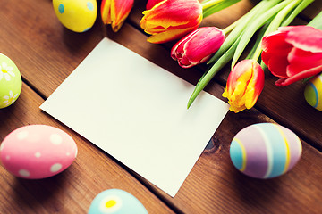 Image showing close up of easter eggs, flowers and white paper