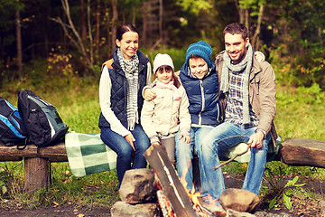 Image showing happy family sitting on bench at camp fire