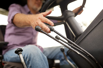 Image showing senior man driving tractor at farm