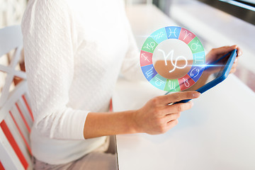 Image showing woman with tablet pc and zodiac signs at cafe