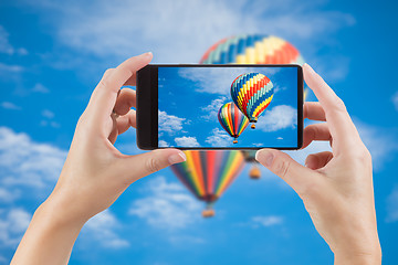 Image showing Female Hands Holding Smart Phone Displaying Photo of Blue Sky wi