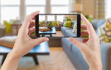 Image showing Female Hands Holding Smart Phone Displaying Photo of House Inter