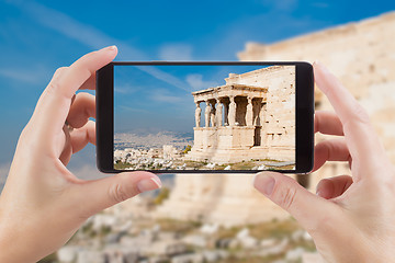 Image showing Female Hands Holding Smart Phone Displaying Photo of Caryatids i