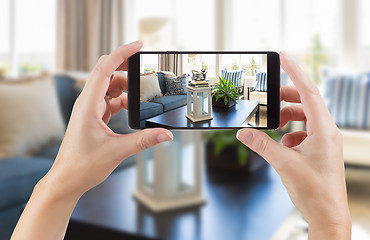 Image showing Female Hands Holding Smart Phone Displaying Photo of House Inter