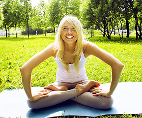 Image showing young pretty blond girl doing yoga in green sunny park at morning, lifestyle sport people concept 