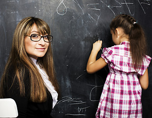 Image showing  woman teacher with little cute blonde girl pupil writing on blackboard together, lifestyle people concept 