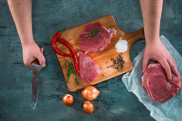 Image showing Butcher cutting pork meat on kitchen