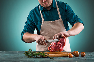 Image showing Butcher cutting pork meat on kitchen