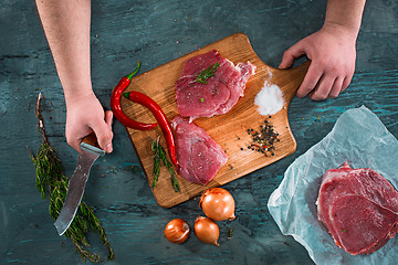 Image showing Butcher cutting pork meat on kitchen