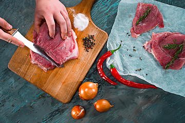 Image showing Butcher cutting pork meat on kitchen
