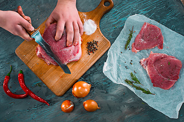 Image showing Butcher cutting pork meat on kitchen