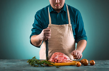 Image showing Butcher cutting pork meat on kitchen