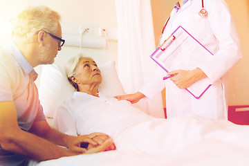 Image showing senior woman and doctor with clipboard at hospital