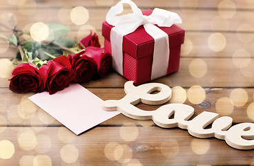 Image showing close up of gift box, red roses and greeting card