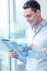 Image showing smiling businessman with tablet pc in office