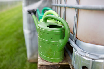 Image showing watering cans at farm water tank