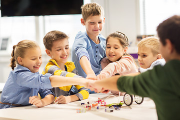 Image showing happy children making fist bump at robotics school