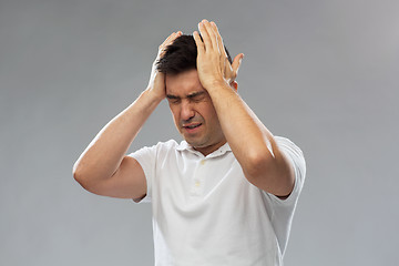 Image showing unhappy man suffering from head ache