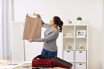 Image showing woman packing travel bag at home or hotel room