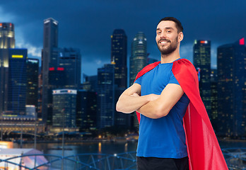 Image showing happy man in red superhero cape over night city