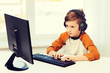 Image showing boy with computer and headphones at home