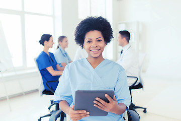 Image showing happy nurse with tablet pc over team at hospital