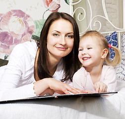 Image showing mother with daughter together in bed smiling, happy family close up, lifestyle people concept, cool real modern family playing