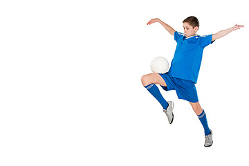 Image showing Young boy with soccer ball doing flying kick