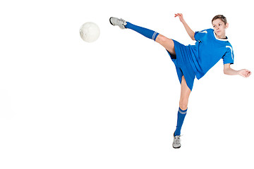 Image showing Young boy with soccer ball doing flying kick