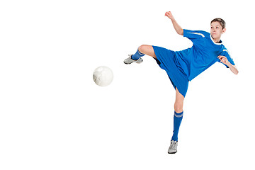 Image showing Young boy with soccer ball doing flying kick