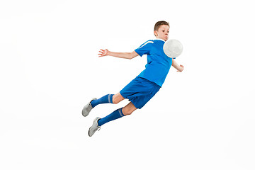 Image showing Young boy with soccer ball doing flying kick