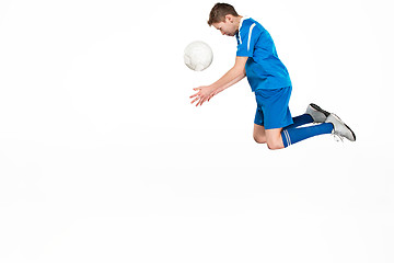 Image showing Young boy with soccer ball doing flying kick