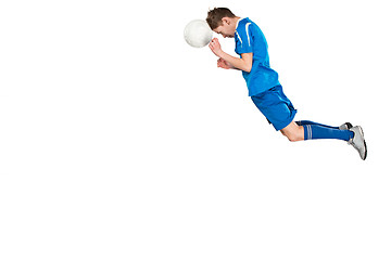 Image showing Young boy with soccer ball doing flying kick