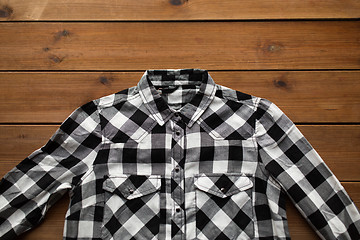 Image showing close up of checkered shirt on wooden background