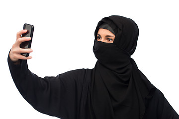 Image showing muslim woman in hijab taking selfie by smartphone