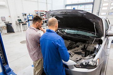 Image showing auto mechanic and man or car owner at workshop