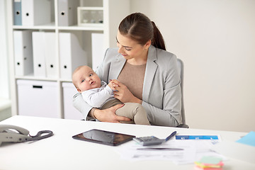 Image showing happy businesswoman with baby working at office